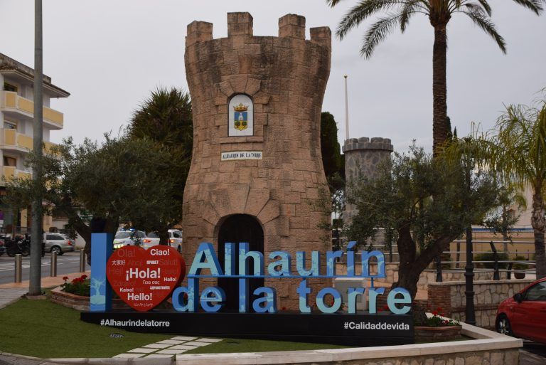 El monumento a la torre incorpora un letrero con el nombre del municipio y un guiño a los turistas